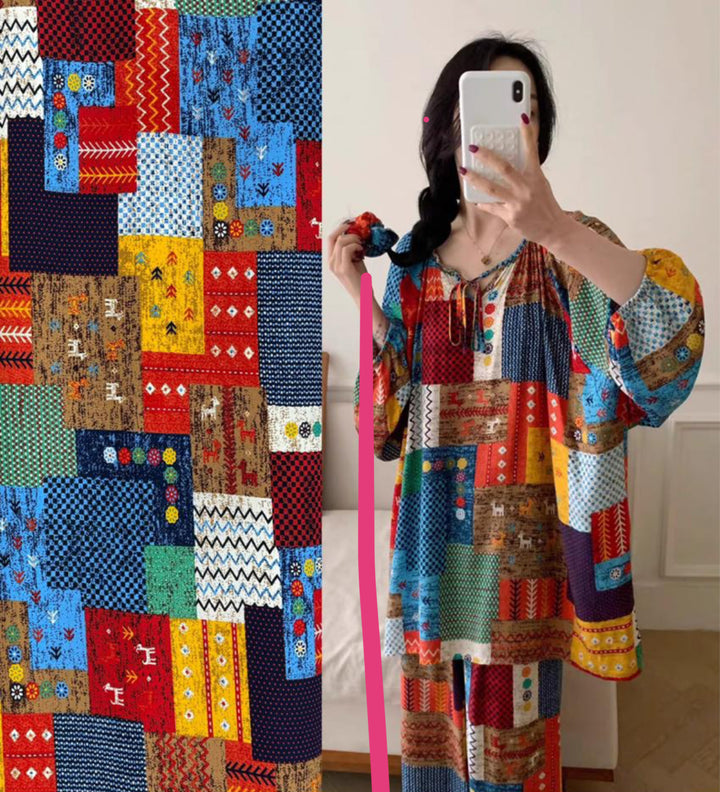 A person takes a mirror selfie wearing a loose, long-sleeved dress made from Super Cheap Fabrics’ Designer Rayon - Andes Patchwork (147cm), featuring bright geometric and floral prints matching the fabric sample shown beside them.