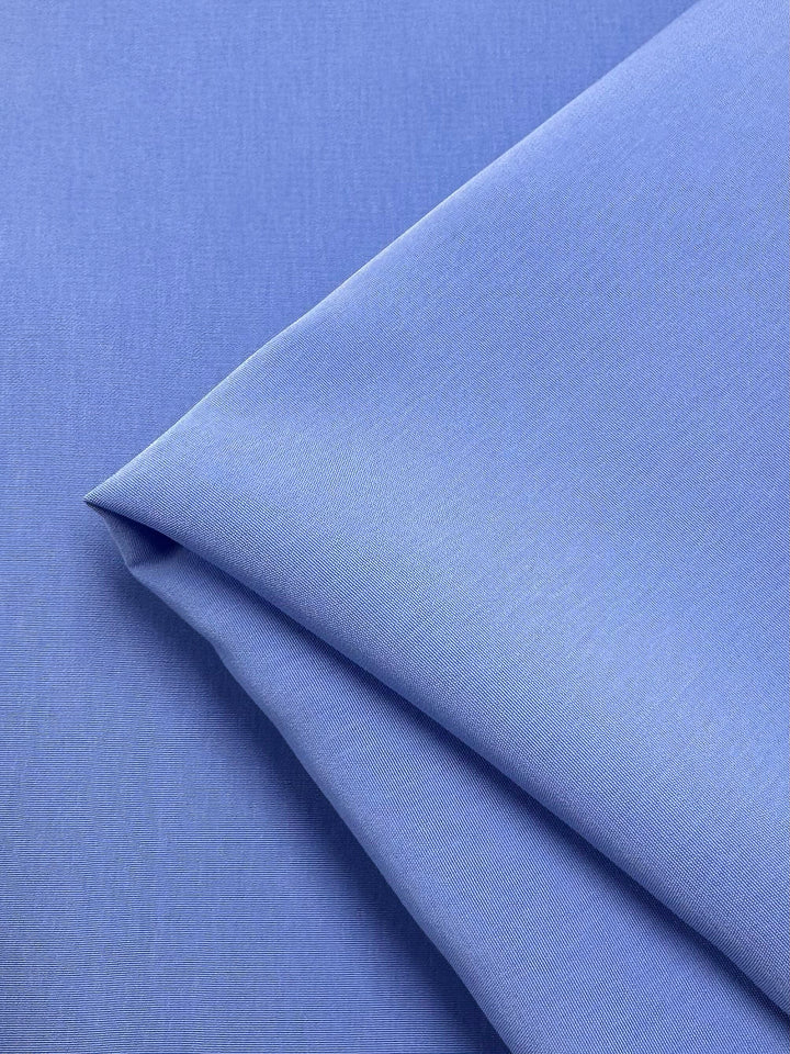 The Microfibre Suiting - Azurine by Super Cheap Fabrics features a neatly folded, smooth microfibre surface with a soft sheen and medium weight, highlighting its crispness and quality. Width: 150cm.