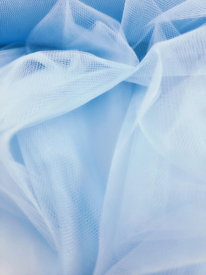 Close-up of Soft Tulle - Spun Sugar - 150cm by Super Cheap Fabrics, showcasing its sheer, airy blue material with delicate folds—ideal for crafts or creating dreamy bridal veils.