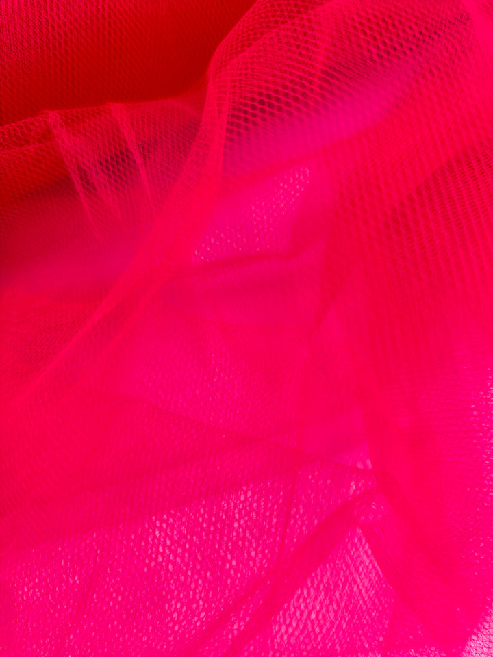 Soft Tulle - Teaberry by Super Cheap Fabrics is a bright pink, 150cm-wide fabric ideal for bridal veils, featuring layered, airy mesh with visible folds for a soft texture.