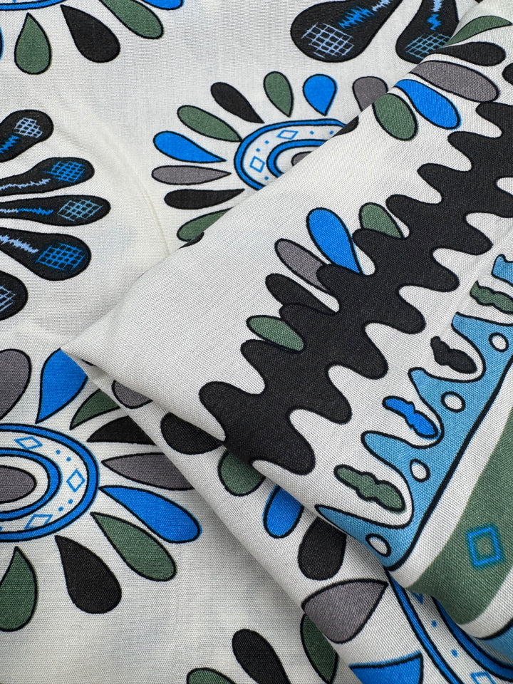 Close-up of Designer Rayon - Dance by Super Cheap Fabrics: a lightweight 145cm rayon featuring bold abstract teardrop shapes, dots, and curved lines in black, blue, and green—ideal for vibrant print lovers.