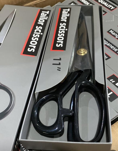 Close-up of Super Cheap Fabrics' Tailor Scissors, 11-inch dressmaking shears with black ergonomic handles, showcased in packaging. The box highlights qualities such as "High Quality," "Non-Slip Grip," and "Japanese Steel.