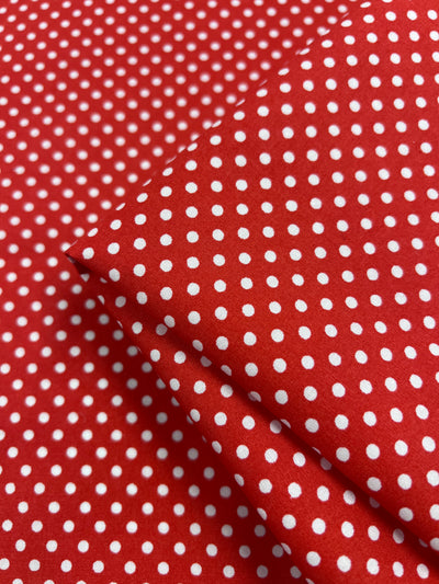 The Cotton Dots Mini - Red, by Super Cheap Fabrics, is a folded red fabric with a white polka dot pattern made from lightweight 112cm cotton.