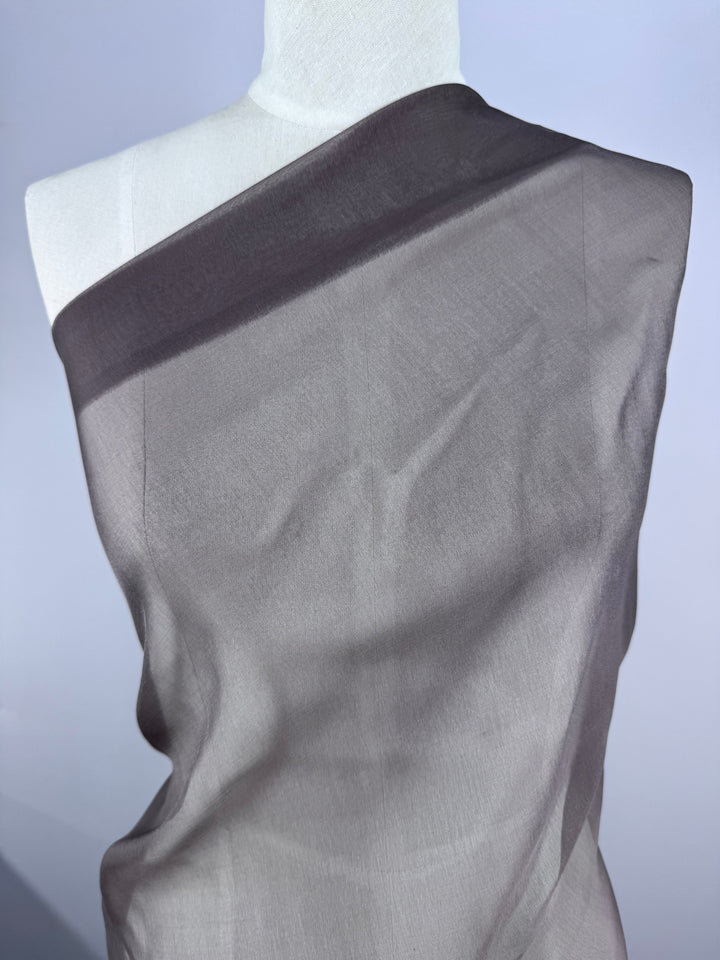 A white mannequin is draped in Super Cheap Fabrics' Blended Silk Mousseline - Pewter (147cm), a sheer, extra lightweight fabric, set against a light background.