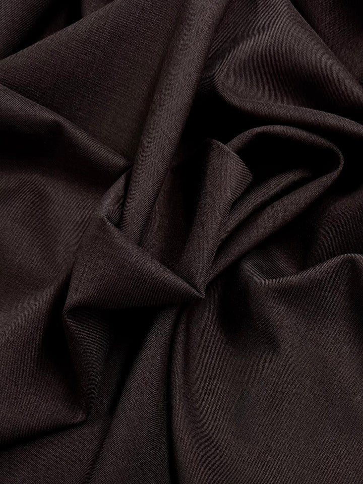 Super Cheap Fabrics' Twill Suiting - chocolate - 150cm features a smooth-textured dark brown fabric that drapes loosely, creating soft folds and creases.