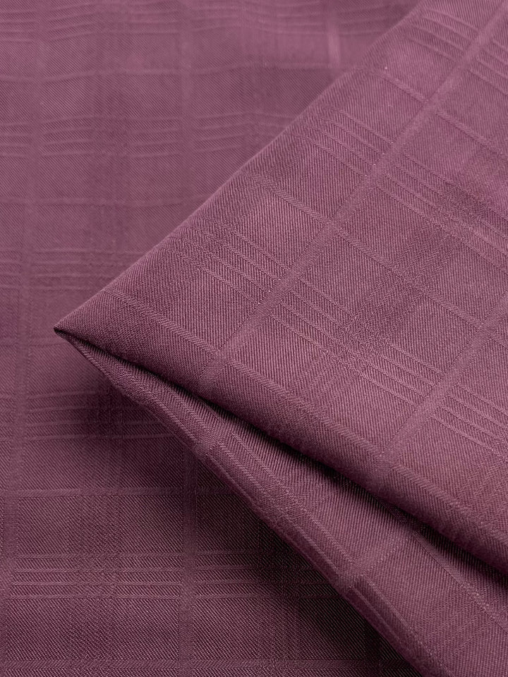 Close-up of Suiting - Mauve Tartan by Super Cheap Fabrics, showcasing its maroon and mauve tartan pattern with a soft, textured surface. This lightweight 100% polyester suiting adds elegance with its geometric design.