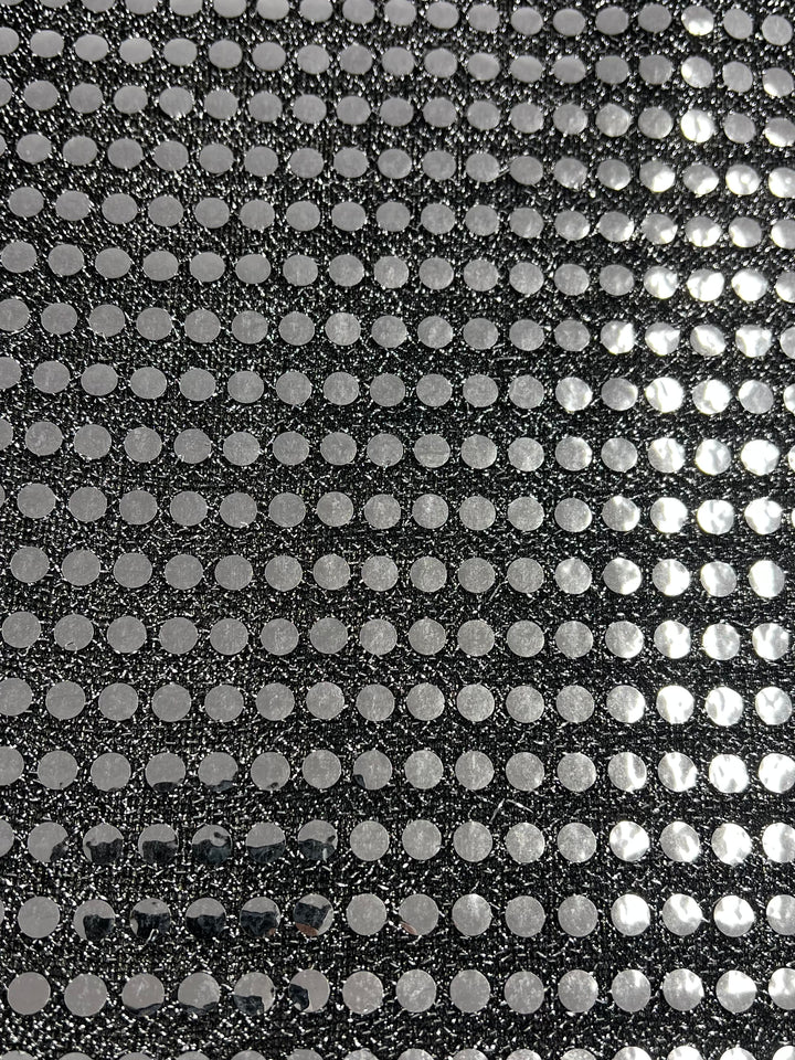Close-up of Super Cheap Fabrics’ Sequin - Black & Silver - 112cm, showcasing a repeating grid of shiny silver dots on black, resembling metallic, textured dancewear fabric.
