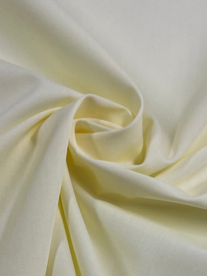A close-up of Super Cheap Fabrics’ Poplin - Glass Green (112cm) shows lightweight, non-stretch polyester cotton with soft folds and gentle draping, offering a smooth texture, subtle shadows, and elegant movement.