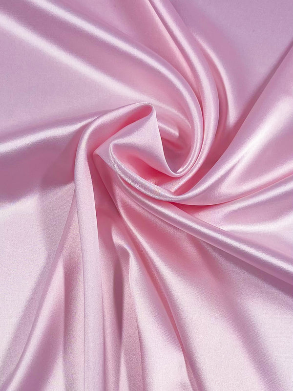 Satin Deluxe - Primrose by Super Cheap Fabrics is a smooth, shiny pink polyester satin (150cm wide) that drapes in gentle folds, reflecting light for a soft and elegant look.