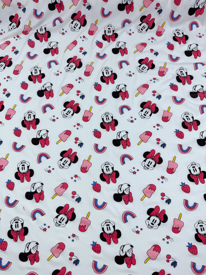 The Super Cheap Fabrics "Minni Summer" printed jersey is a medium-weight, two-way stretch fabric featuring cartoon mice with bows, red popsicles, strawberries, and rainbows on white.