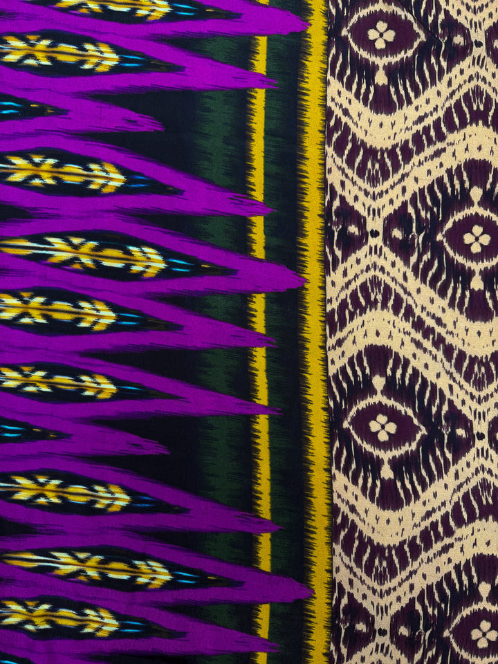 A close-up of Super Cheap Fabrics' Printed Viscose - Regal Ikat (145cm) shows purple, yellow, and green zigzags on one side, and a cream and brown abstract diamond motif on the other.