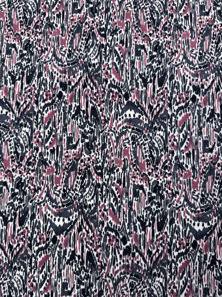 Super Cheap Fabrics presents Printed Lycra - Grey Musk - 150cm with an abstract pattern in black, white, and pink. Its medium-weight fabric features irregular shapes and lines for a textured, chaotic look akin to artistic designs.