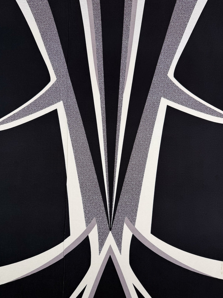 Bold, geometric pattern of sharp black, white, and gray shapes radiates from the center—ideal for statement pieces on Super Cheap Fabrics’ Viscose Knit - Curve - 145cm.