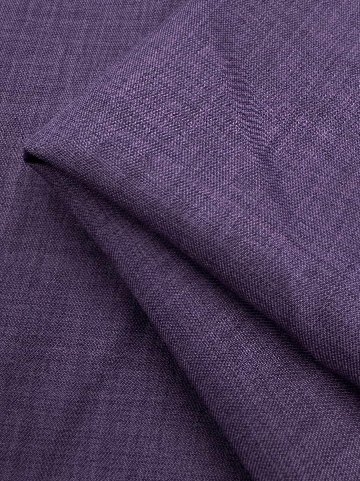 A close-up of Super Cheap Fabrics' Twill Suiting - Wineberry - 150cm reveals fine threads and diagonal creases, highlighting the fabric's signature textured pattern and versatile diagonal twill weave.