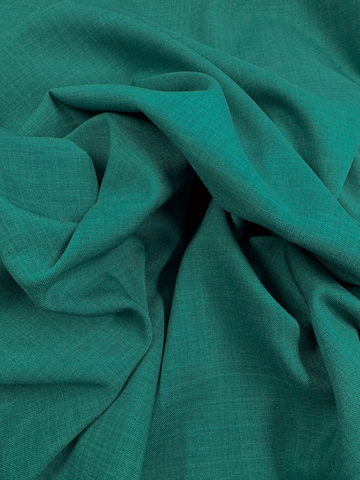 Super Cheap Fabrics' Twill Suiting - Ivy - 150cm features a teal green fabric with soft, natural folds and a subtly textured, diagonal weave that adds gentle shadows and highlights.