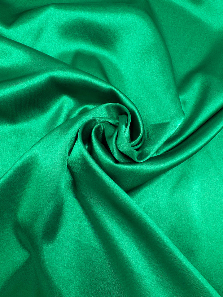 Satin Deluxe - Bosphorus by Super Cheap Fabrics is a shiny emerald green satin (150cm wide) with a smooth texture, draping beautifully for nightgowns or luxury projects.