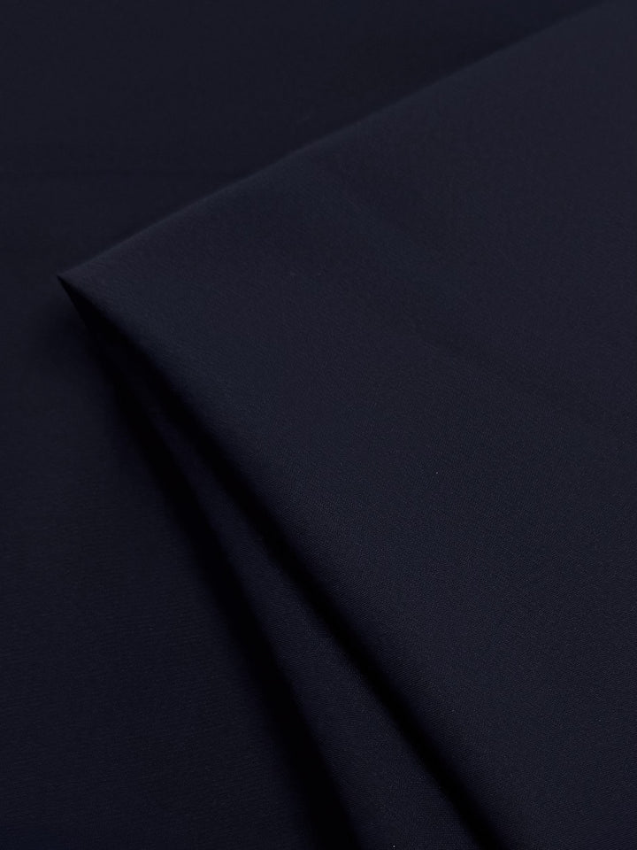 A close-up of Super Cheap Fabrics’ Plain Lycra in black (165cm), neatly folded to reveal its smooth, soft texture—ideal for activewear and swimwear.