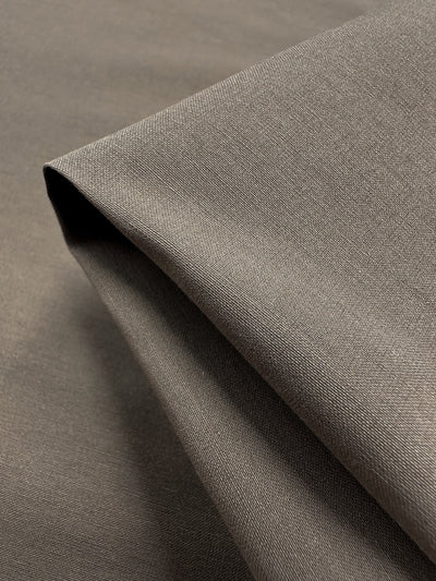 Close-up of Lightweight Bengaline - Moon Rock by Super Cheap Fabrics, displaying a folded piece with subtle sheen and fine texture. The 152cm wide fabric is lightweight and smooth, featuring a slightly glossy, delicately woven pattern for an elegant look.