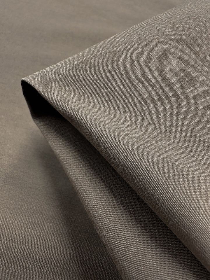 Close-up of Lightweight Bengaline - Moon Rock by Super Cheap Fabrics, displaying a folded piece with subtle sheen and fine texture. The 152cm wide fabric is lightweight and smooth, featuring a slightly glossy, delicately woven pattern for an elegant look.