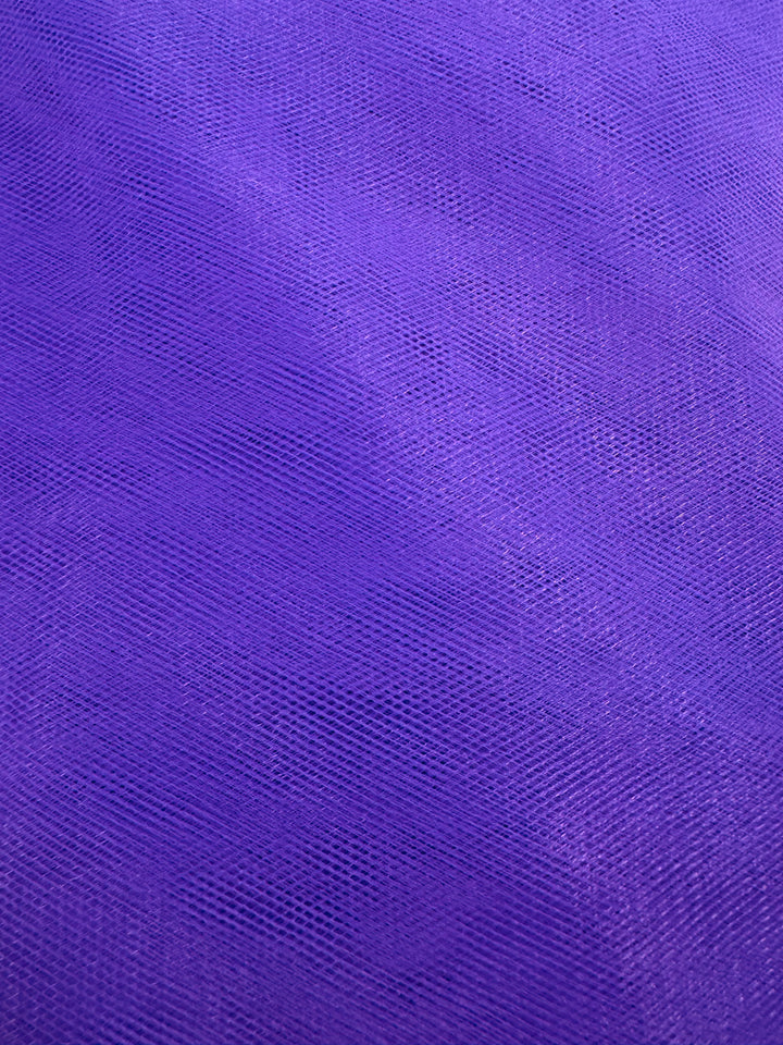 Close-up of Super Cheap Fabrics’ Soft Tulle - Purple - 150cm shows its fine mesh and subtle crisscross texture, with lighting emphasizing the fabric’s lightweight, airy quality ideal for bridal veils.