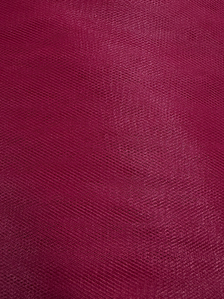 Close-up of Soft Tulle - Emboldened - 150cm by Super Cheap Fabrics in a rich burgundy shade, featuring a textured surface with subtle patterns and delicate light-and-shadow variations, ideal for bridal veils or costumes.