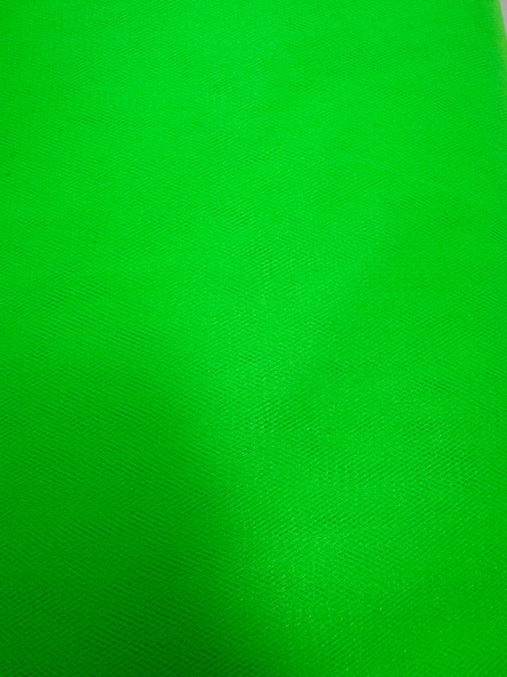 Close-up of Soft Tulle - Neon Lime - 150cm by Super Cheap Fabrics: bright green textured fabric with subtle diagonal lines and shadows, perfect for bridal veils or standout costumes.