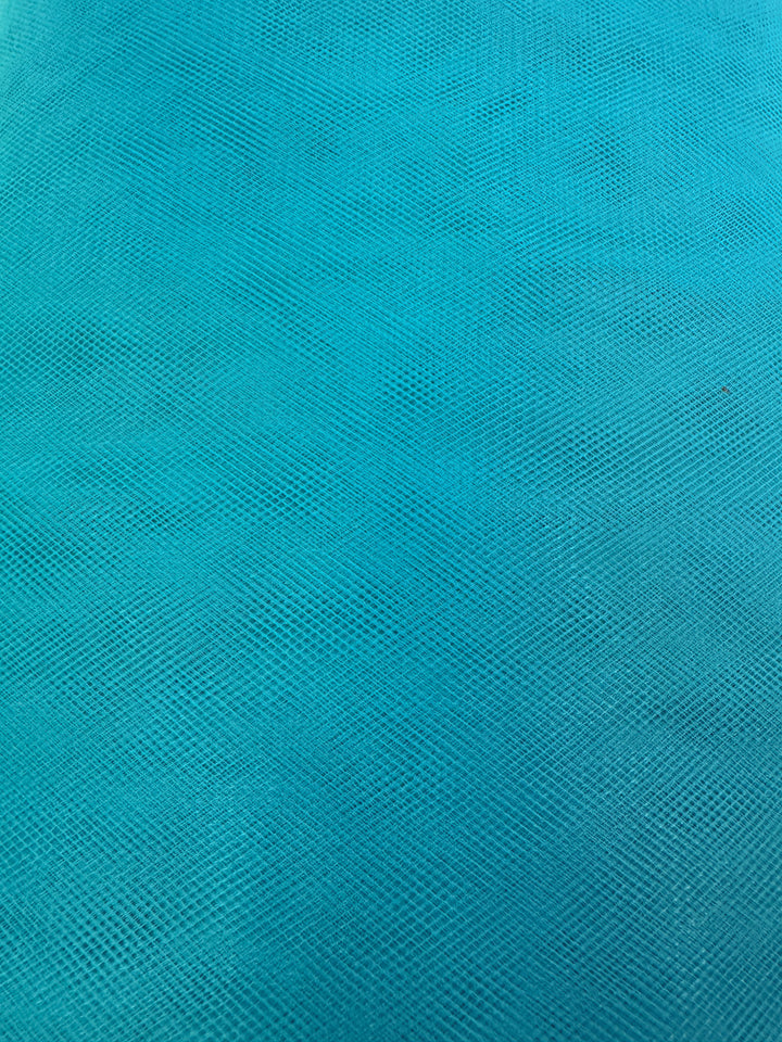 Close-up of Super Cheap Fabrics' Soft Tulle in Lake Blue (150cm), featuring a vibrant, consistent shade and subtle woven mesh pattern—ideal for craft projects or tulle fabrics with intersecting lines and slight texture variations.