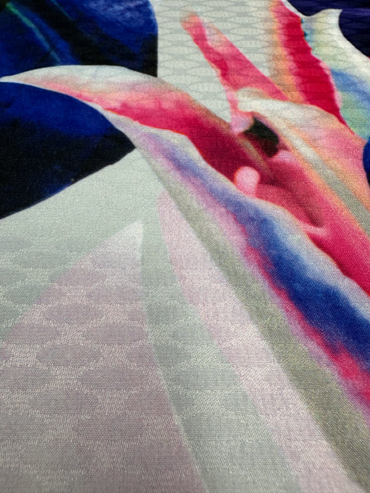 The Textured Poly Sateen - Fawna by Super Cheap Fabrics features an abstract pattern with vibrant pink, blue, and green hues. Its flowing lines and smooth textures offer an artistic, dynamic look ideal for household décor. Width is 150cm.