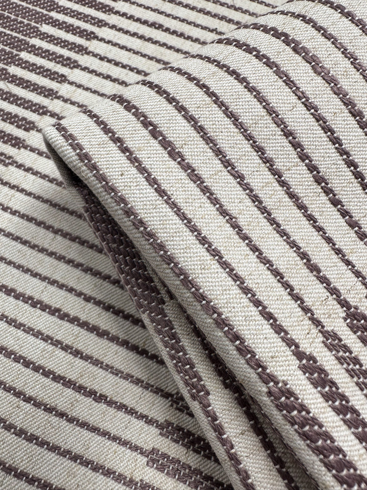 A close-up of Striped Woven Upholstery - Melmoth by Super Cheap Fabrics (142cm), featuring a burlwood-inspired beige fabric with brown linear and diagonal stripes, showcasing its thick, durable texture.