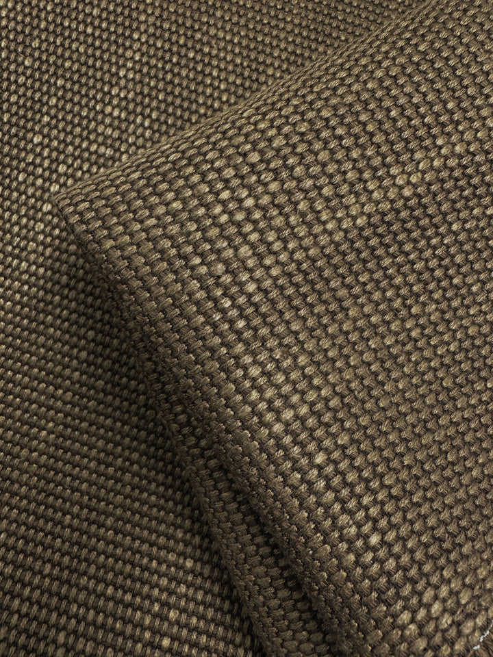 Close-up of Grid Upholstery - Yari 014 (147cm) by Super Cheap Fabrics, featuring earthy brown heavy weight fabric with a diagonal fold, revealing a detailed interlaced fiber pattern that showcases high durability.