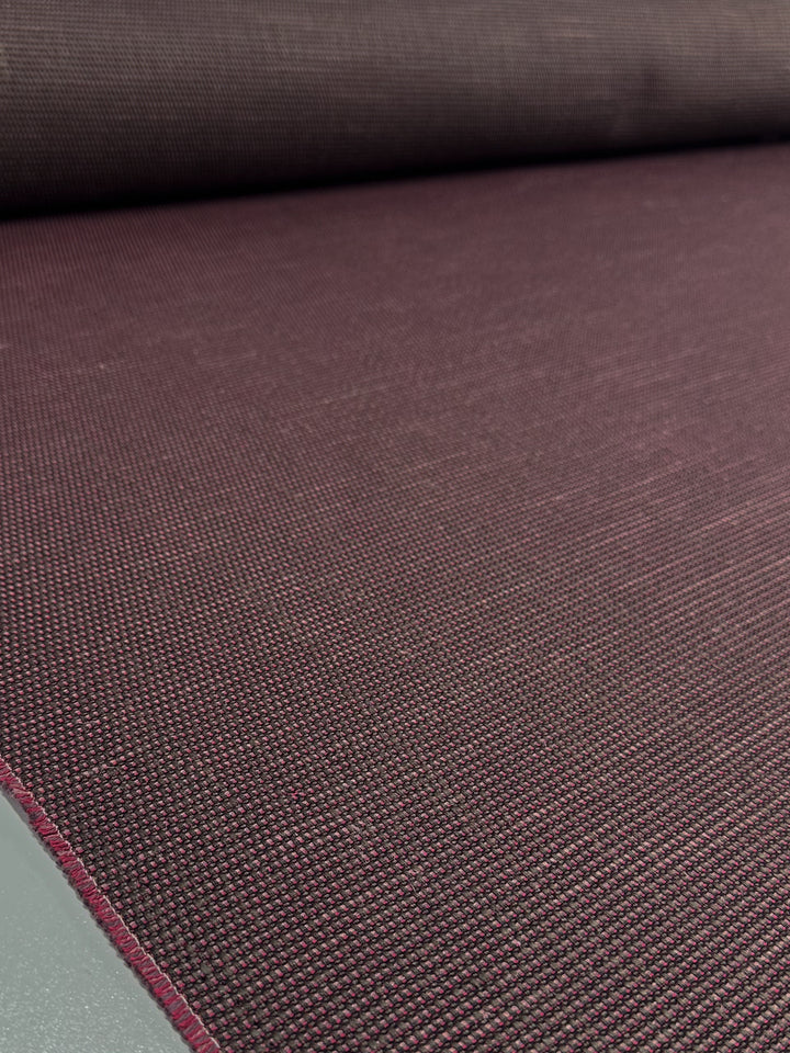 A close-up of Super Cheap Fabrics' Grid Upholstery - Yari 125 (147cm) shows the textured, heavy weight dark burgundy fabric laid flat, highlighting its fine woven details.