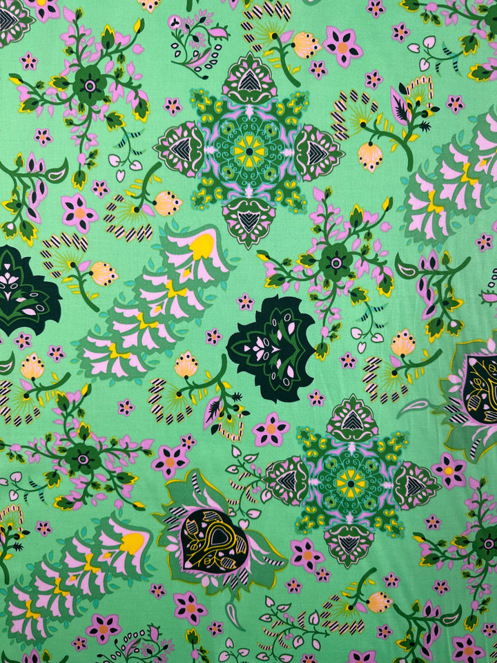 Super Cheap Fabrics’ Cotton Sateen - Lime Mosaic (145cm) features a lively floral and geometric pattern on green, with pink, yellow, and dark green accents—ideal for stylish home décor projects.