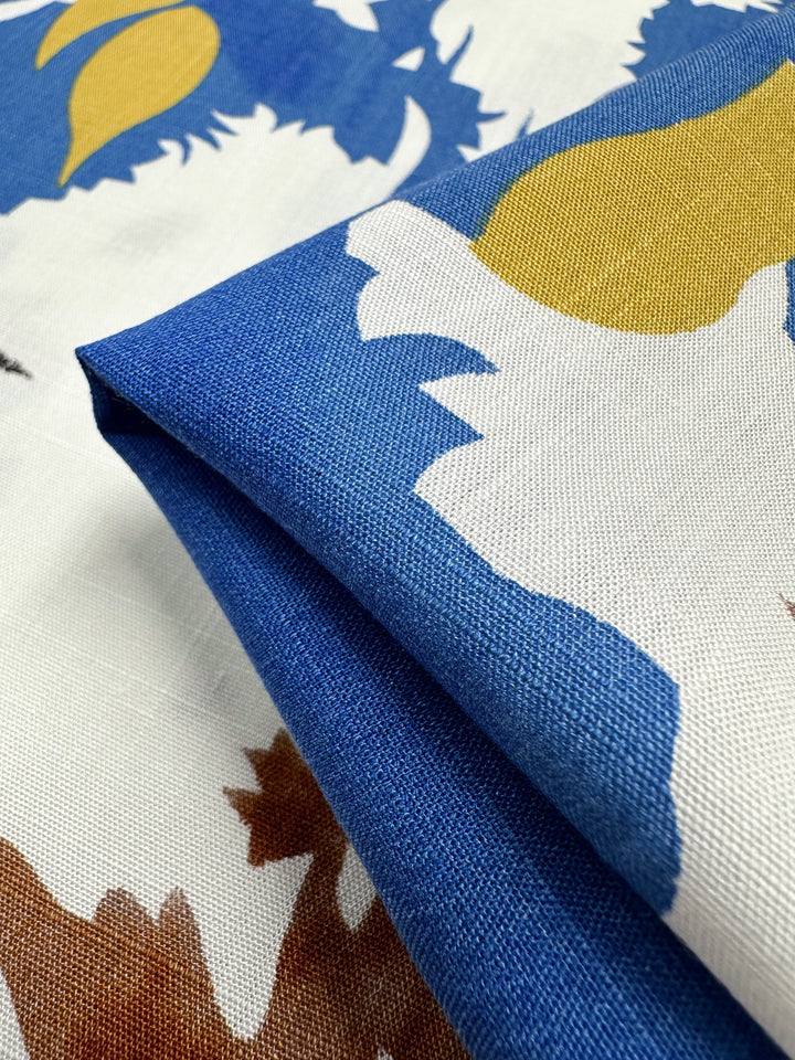 A close-up of Super Cheap Fabrics’ Bamboo Rayon - Splash (150cm) shows its lightweight texture and bold abstract pattern in blue, yellow, brown, and white—perfect for sewing projects.