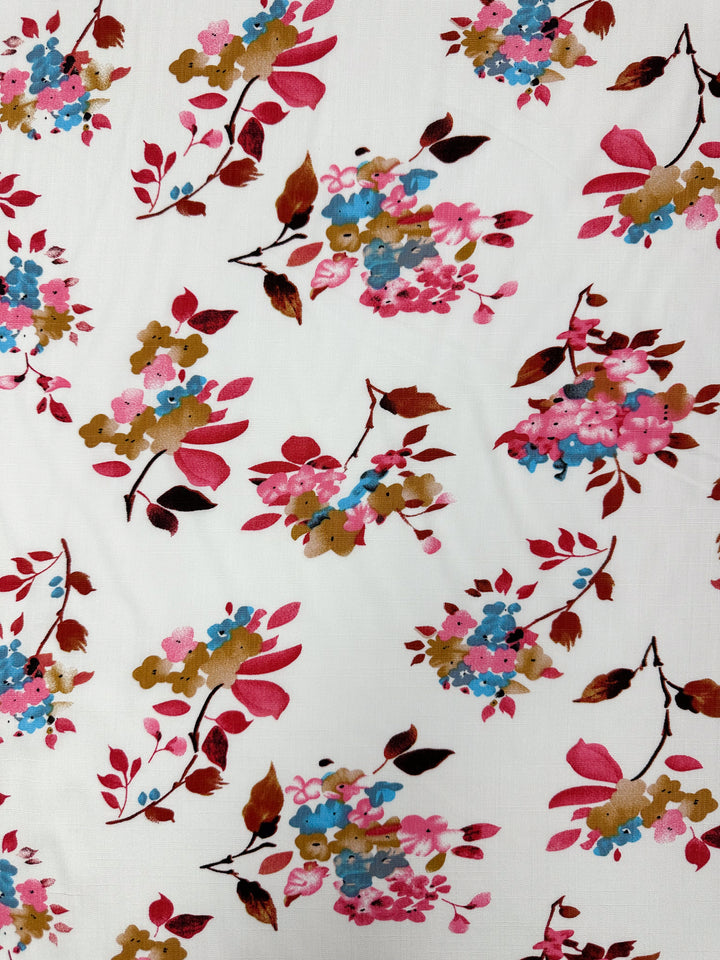 Bamboo Rayon - Lil Flower - 150cm by Super Cheap Fabrics: a lightweight white bamboo rayon fabric with colorful clusters of pink, blue, red, and brown flowers plus leaves—ideal as a versatile multi-use textile.