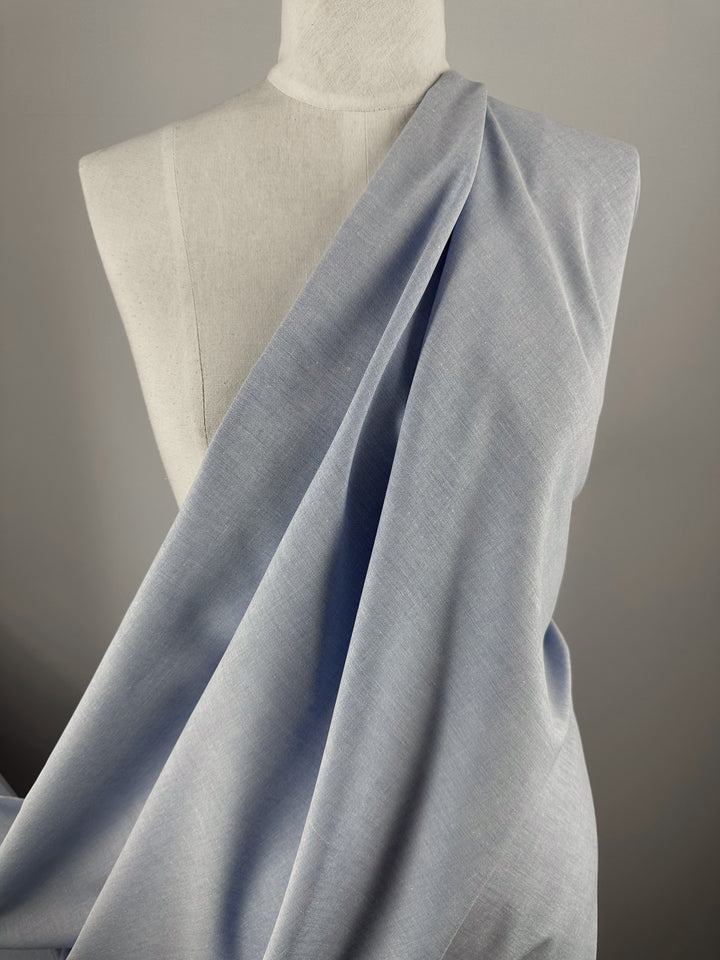 A dress form showcases Super Cheap Fabrics' Oxford Cotton in Little Boy Blue (146cm), draped diagonally across the torso, set against a plain gray background.