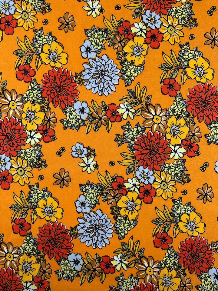 The Printed Linen Blend - Golden Garden (128cm) by Super Cheap Fabrics features a vibrant floral pattern in red, yellow, and blue with green leaves on Inca gold—ideal for bold, lively medium weight linen projects.