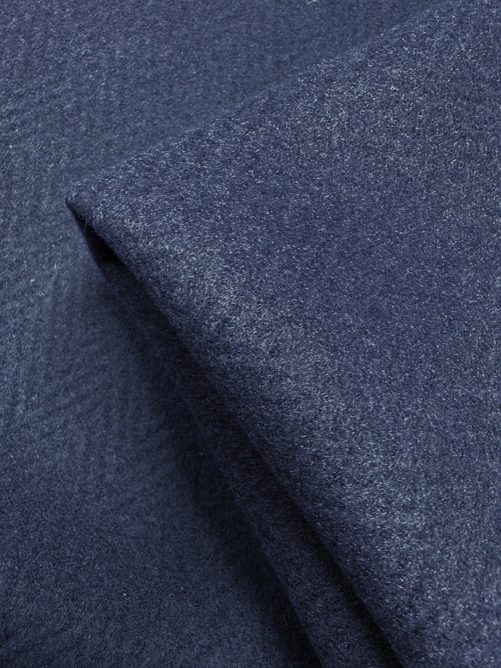 A close-up of Pressed Fleece Coating - Chevron by Super Cheap Fabrics shows folded navy fabric with a subtle chevron pattern and soft texture. This medium weight, 160cm wide fabric combines elegance with versatility.