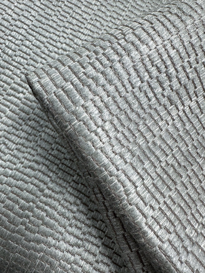Close-up of Cut Pile Jacquard Upholstery - Oscar Gunmetal (142cm) from Super Cheap Fabrics, showing its shiny, textured grid pattern and soft metallic sheen—ideal for sourcing from an Australian fabric wholesaler.