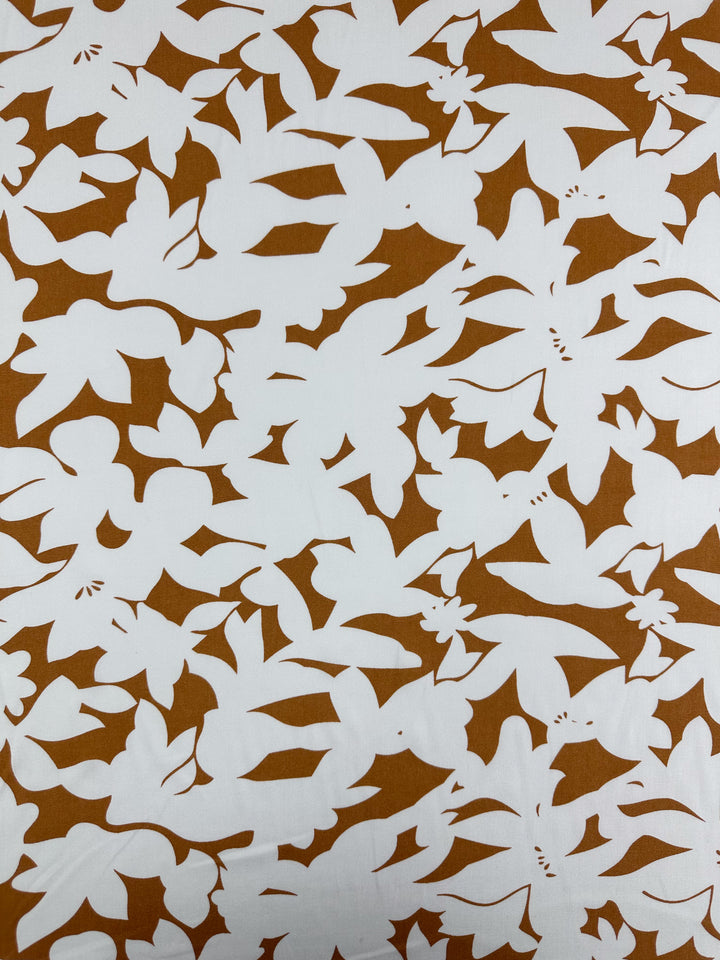 Designer Rayon - Clay Fade by Super Cheap Fabrics is a bold white rayon fabric with an abstract brown floral pattern. Overlapping leaves and flowers create a dense, organic motif with sharp contrast. Width: 145cm.