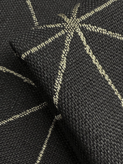 Close-up of Super Cheap Fabrics’ Linen Viscose - Quentin Coal (156cm), featuring heavy weight upholstery fabric with light geometric, star-like stitched lines. A folded piece emphasizes its rich texture and design.