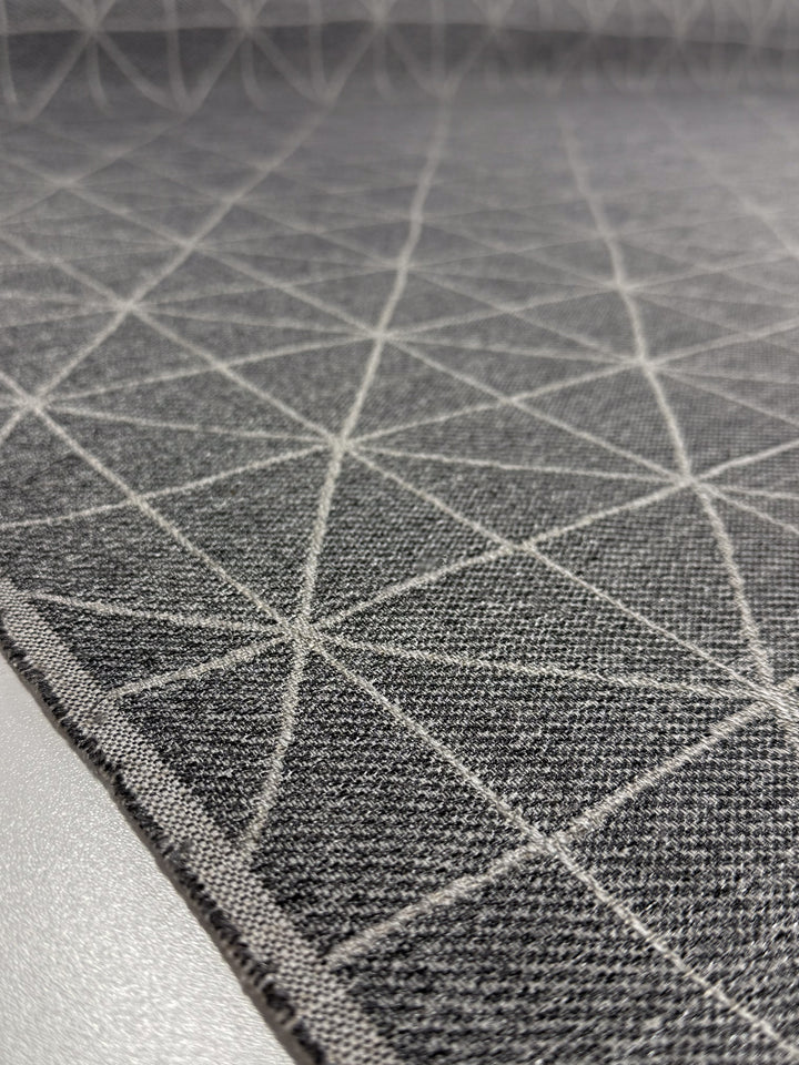 A close-up of Super Cheap Fabrics' Linen Viscose - Quentin Silver (156cm) shows a gray extra heavy weight fabric with intersecting white lines forming geometric triangles, adding a modern, textured look to this luxurious material.