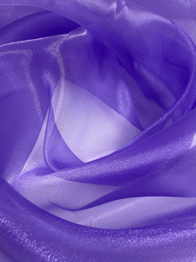 Close-up of Super Cheap Fabrics’ Organza - Sand Verbena - 150cm, a sheer, light purple fabric with a delicate, translucent texture and flowing layers—ideal for highlighting the elegance of lightweight materials.