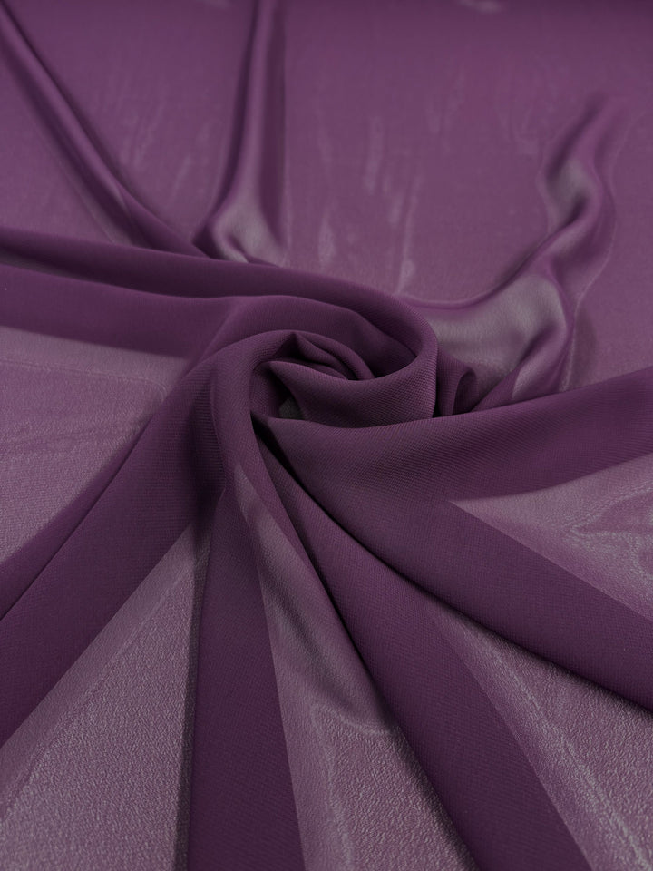 A close-up of Super Cheap Fabrics’ Hi-Multi Chiffon in Plum Purple (150cm), showing its lightweight, semi-transparent texture and sheer, soft spiral arrangement.
