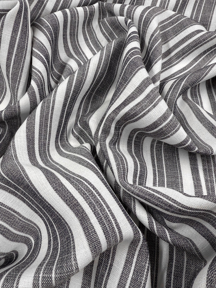Super Cheap Fabrics’ Linen Blend - Linen Stripe - 150cm features black and white stripes in rayon-linen, with wavy folds creating an abstract, dynamic look and textured finish.