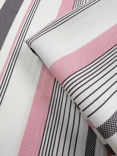 A close-up of Super Cheap Fabrics' Printed Rayon - Candy Noir Stripe (140cm), featuring lightweight rayon in pink, black, and white stripes of varying widths. Soft folds highlight its textured weave and precise stripe alignment.
