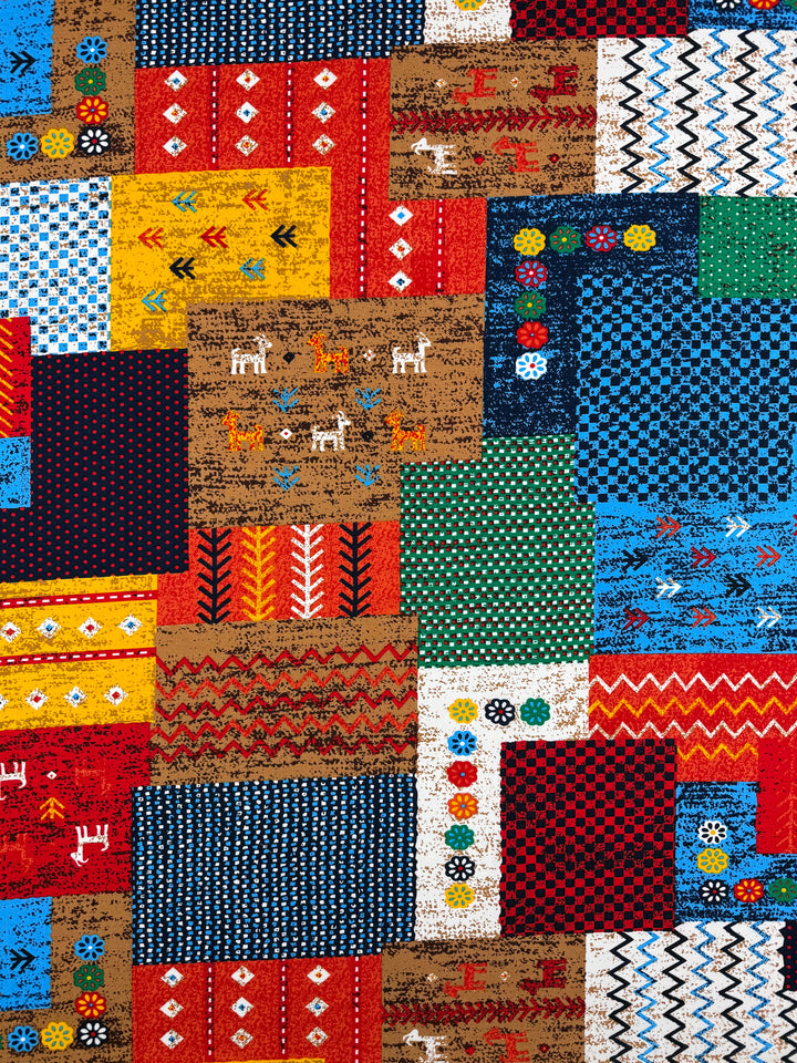 Designer Rayon - Andes Patchwork by Super Cheap Fabrics features a vibrant quilt pattern with geometric shapes and animal motifs in red, blue, green, yellow, and brown on 147cm wide printed rayon.