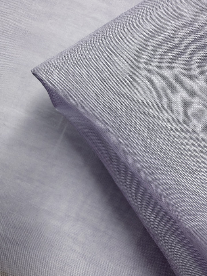 A close-up of Designer Voile - Pastel Lilac - 150cm from Super Cheap Fabrics, showing its fine, smooth texture and neat fold—ideal for those wanting elegant, lightweight cotton voile.