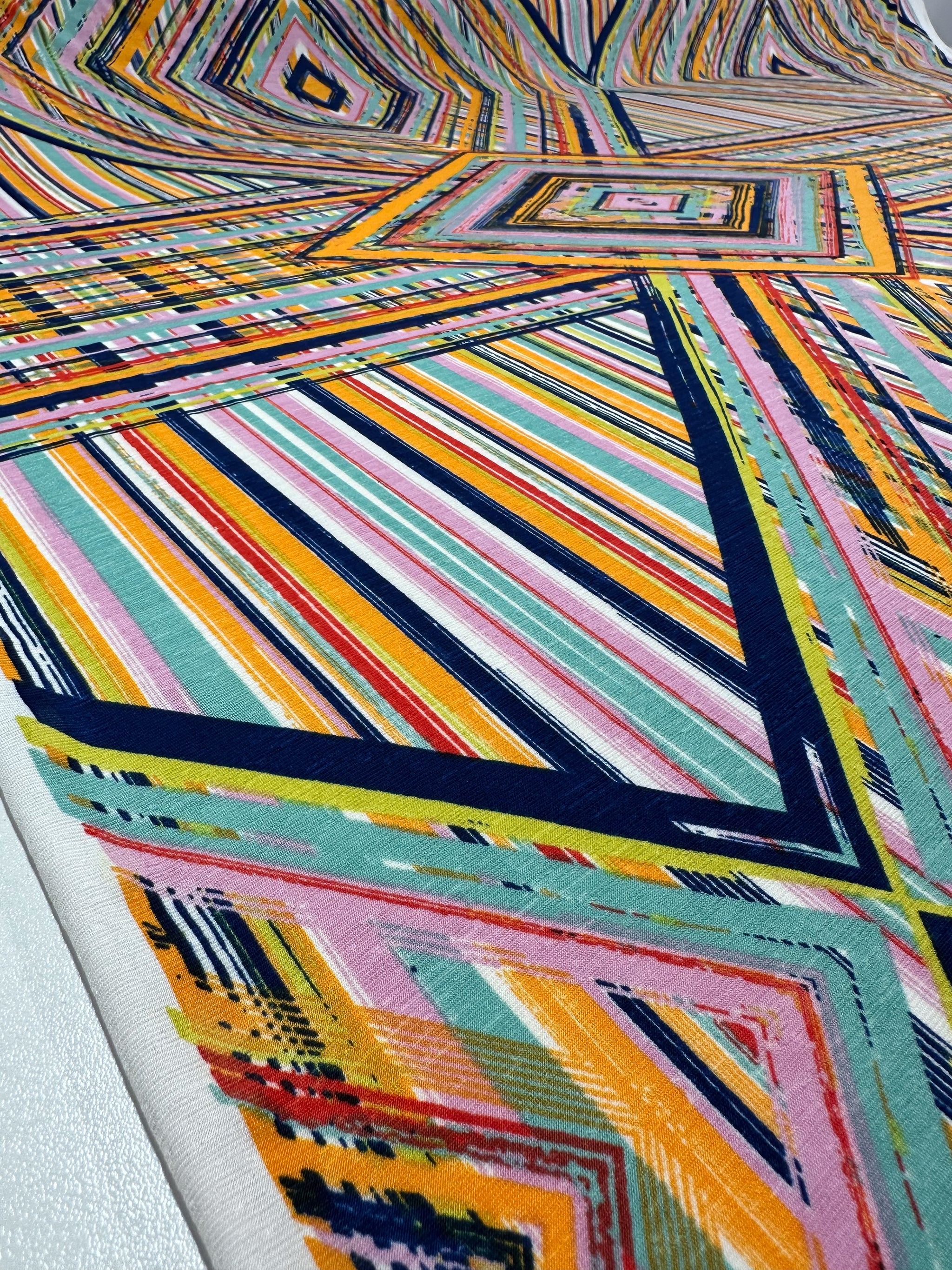 The Geo Dome by Super Cheap Fabrics is a 145cm printed Lycra with vibrant, multicolored geometric patterns. Crafted from silky Polyester Spandex, it features overlapping triangles and stripes in blue, pink, yellow, orange, and green—ideal for dynamic-textured summer garments.