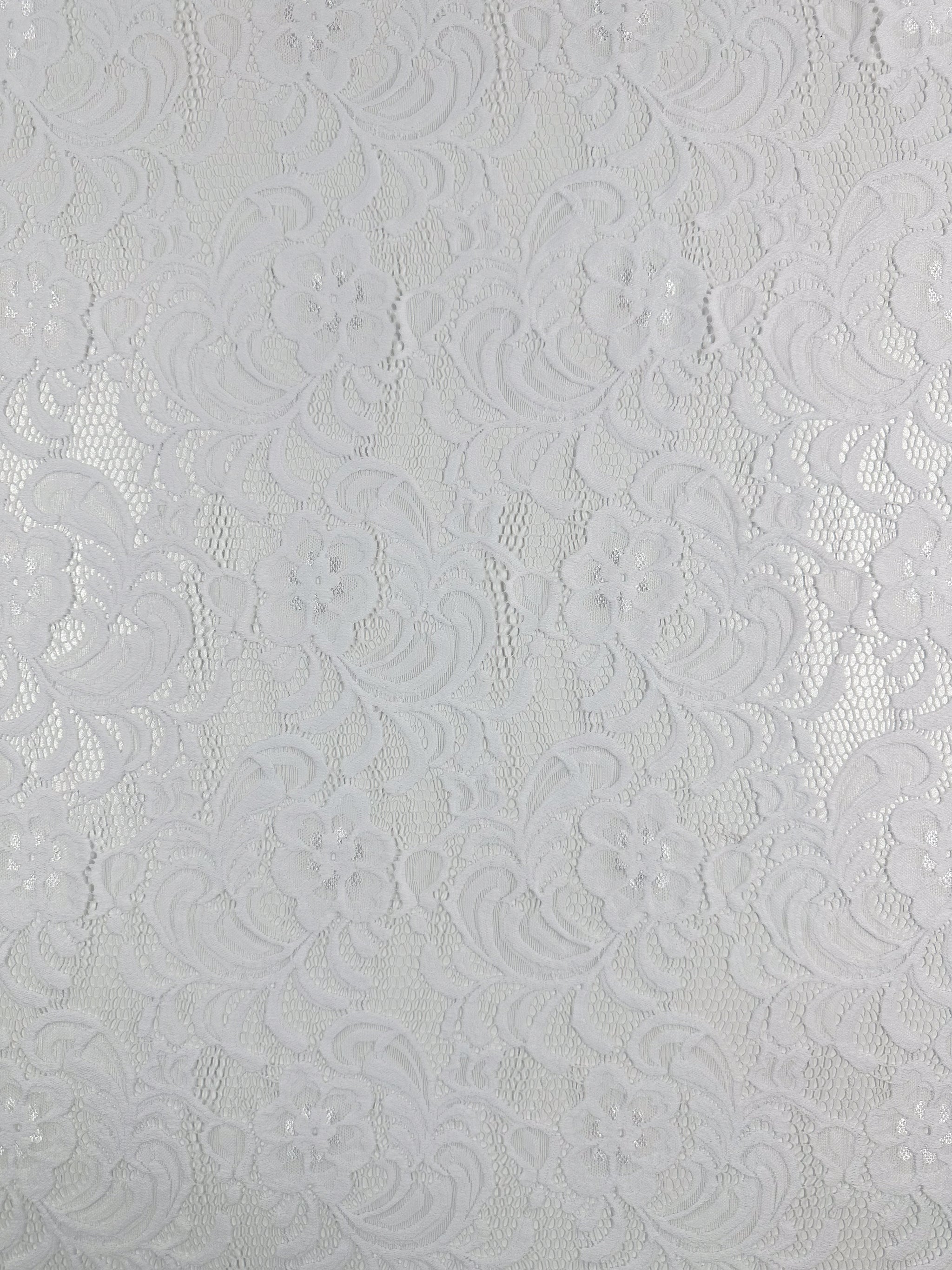 The close-up of Super Cheap Fabrics' Designer Lace in White - 145cm reveals a floral pattern with swirls and mesh, creating a textured and delicate look ideal for evening dresses.