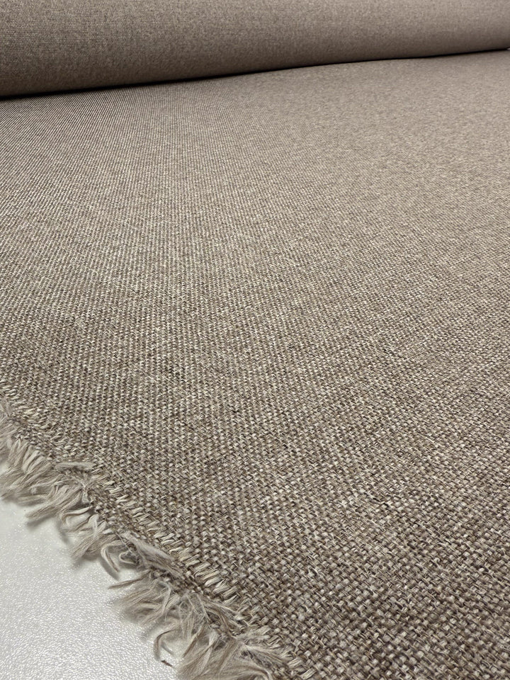 A close-up of Super Cheap Fabrics' Upholstery - Soho Cinnamon - 150cm shows its coarse, wool-look texture with frayed edges and a smooth surface extending into the background.
